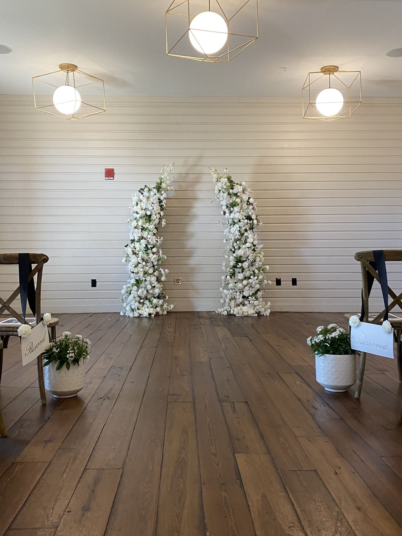 Serenity twin floral arches framing an indoor ceremony space in Tampa Bay