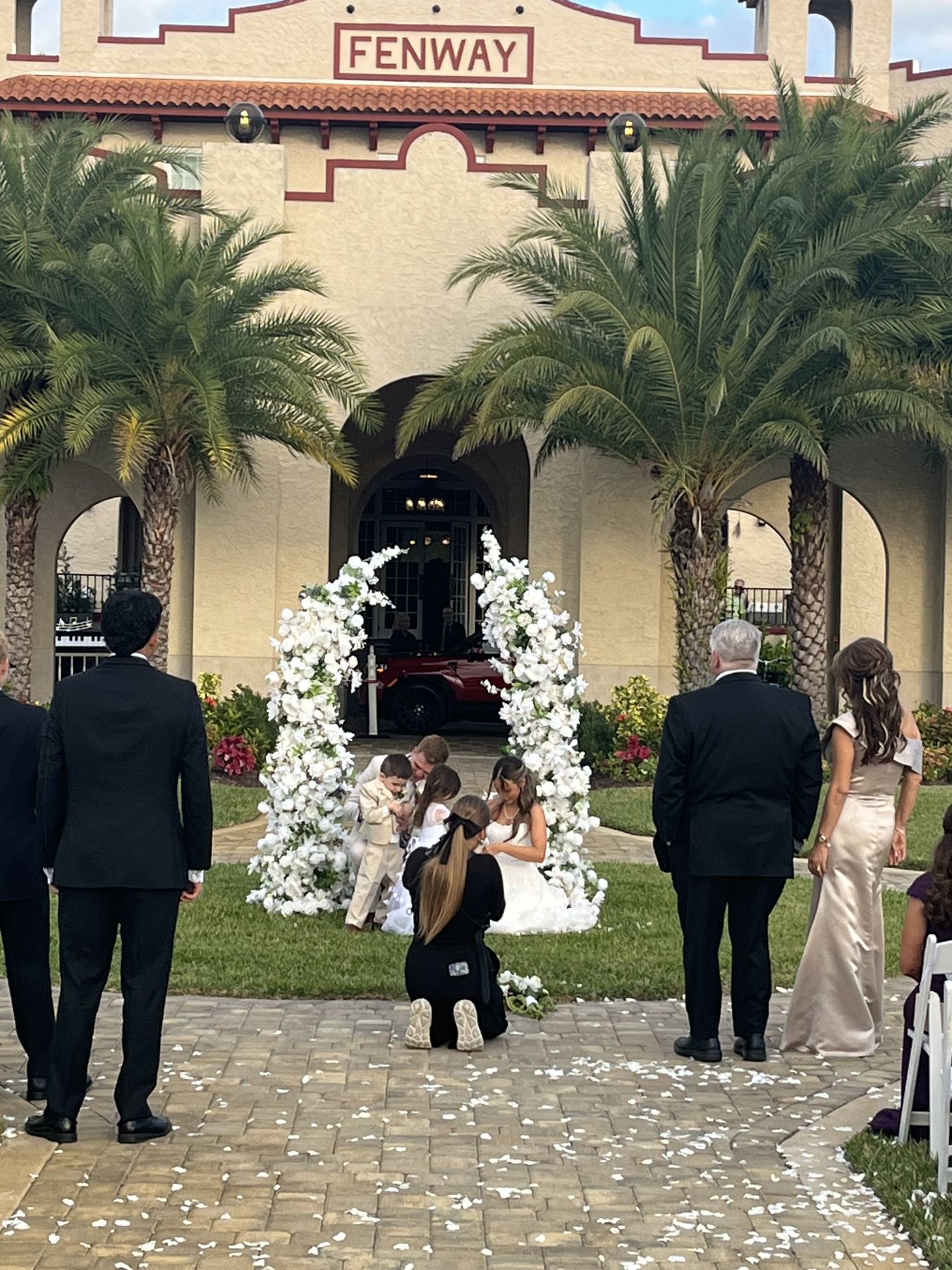 Serenity twin floral arches framing an outdoor wedding ceremony with palm trees in Tampa Bay