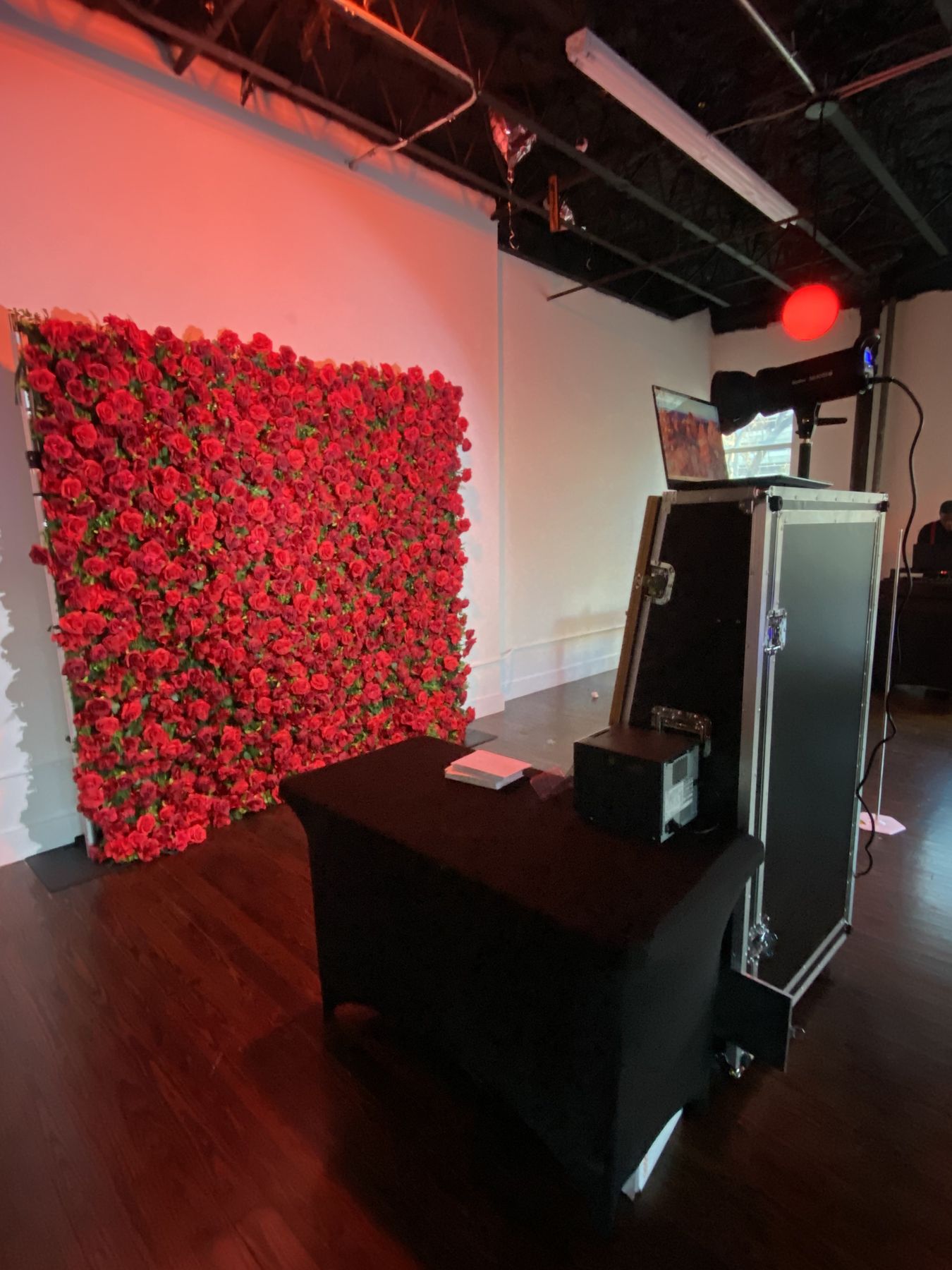 Mirror photo booth beside a red rose flower wall inside a Tampa Bay event venue