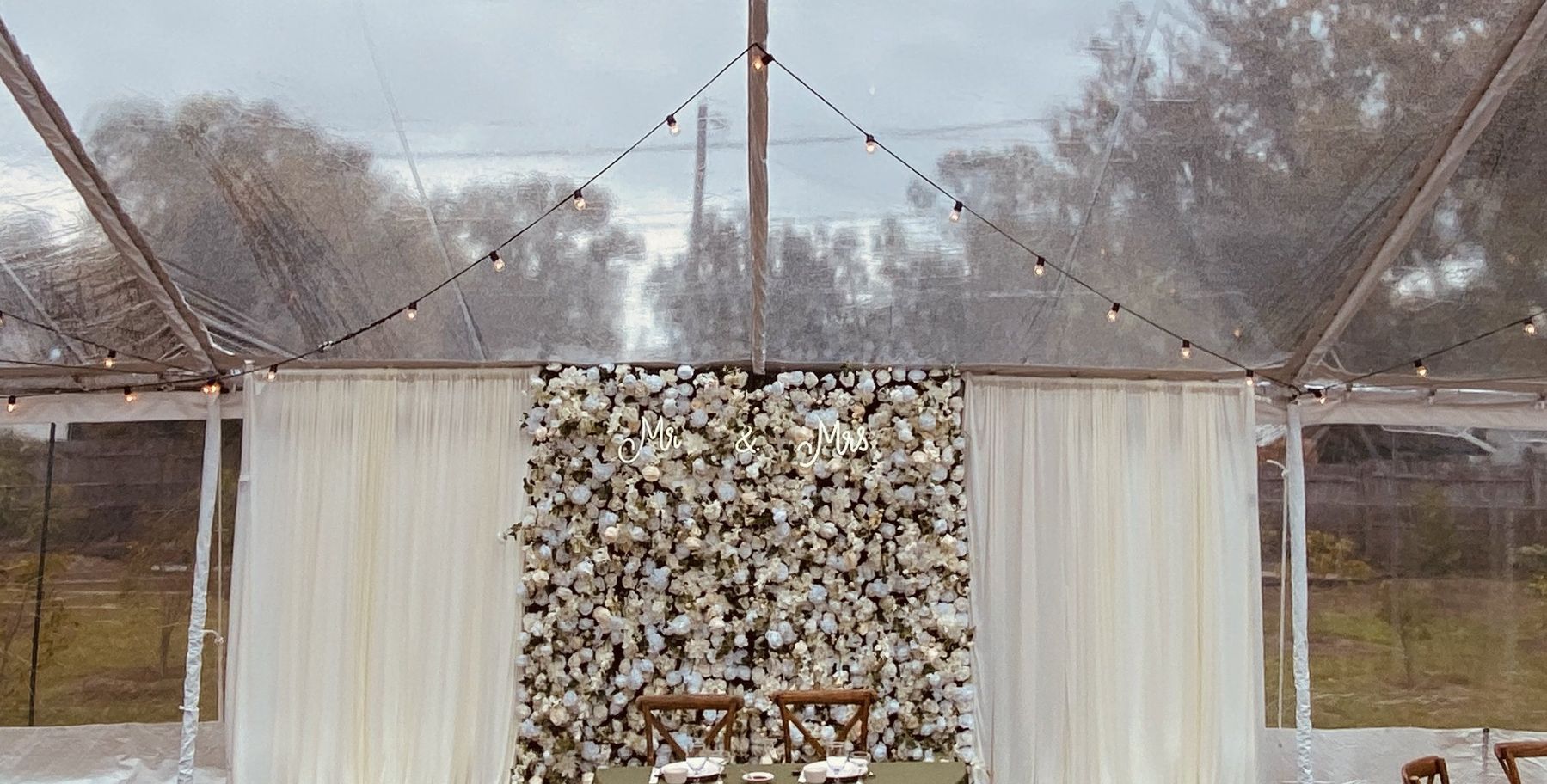 Flower wall with elegant draping and LED sign rental add-ons in Tampa Bay
