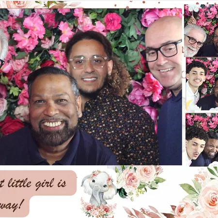 Baby shower guests at the mirror photo booth with a flower wall backdrop in Tampa