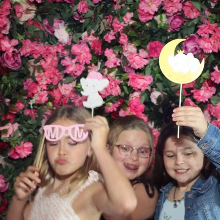 Kids with props at a Tampa Bay baby shower mirror photo booth with flower wall