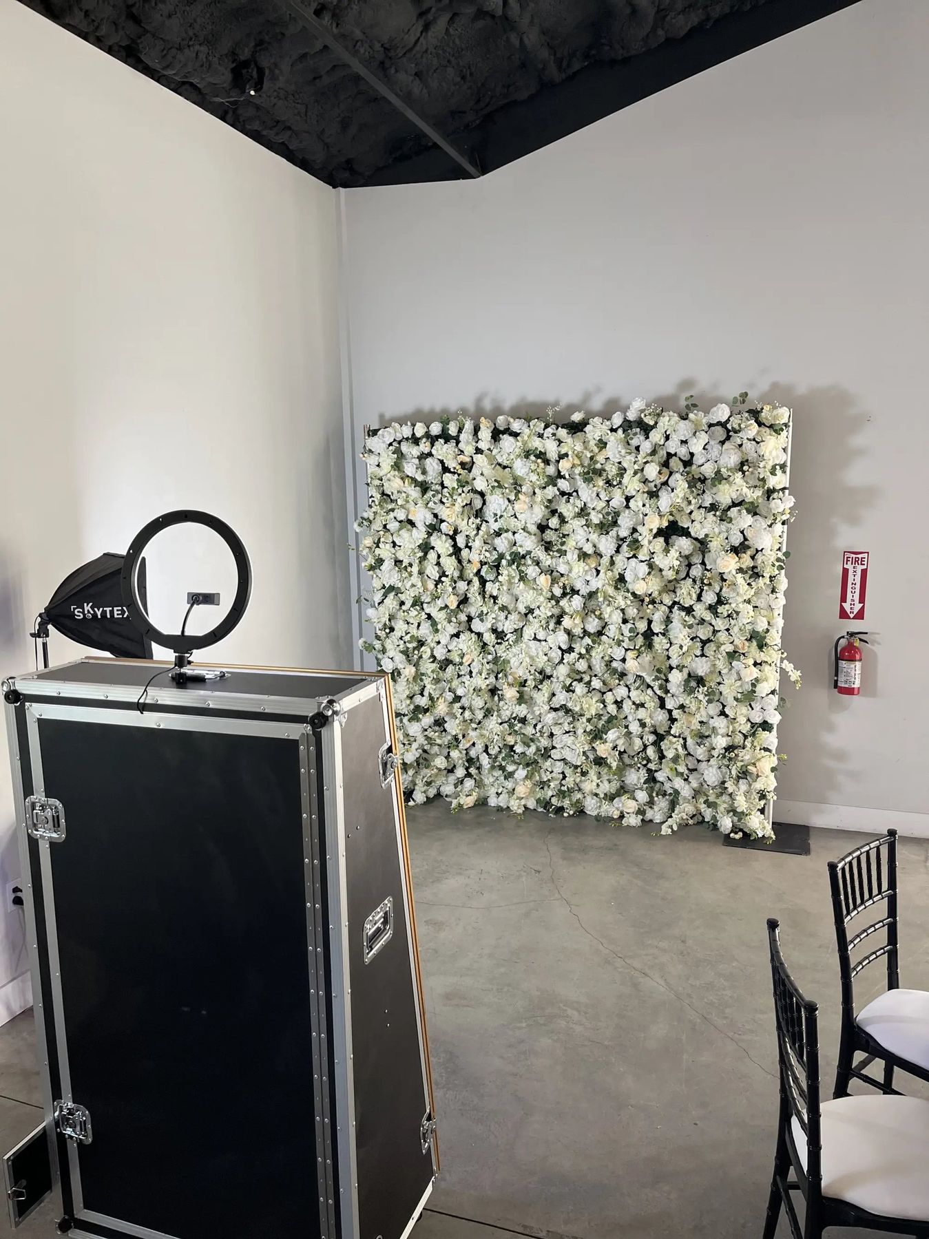 Mirror photo booth with a white rose flower wall along the wall of a Tampa Bay venue